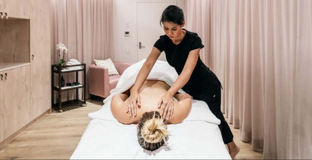 A professional back massage session inside a luxury room at Sol Spa.
