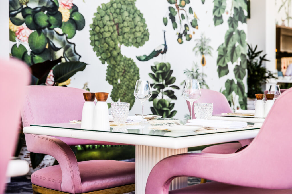 The Botanica Vaucluse featuring pink velvet chairs and a lush botanical wall mural.
