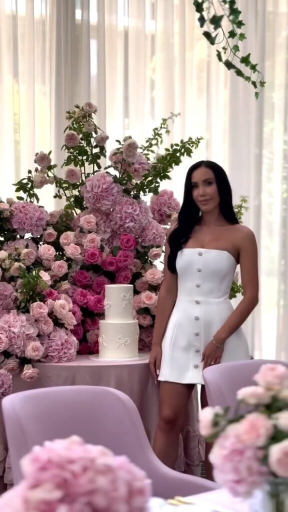 A girl standing on a cake with flowers backdrop